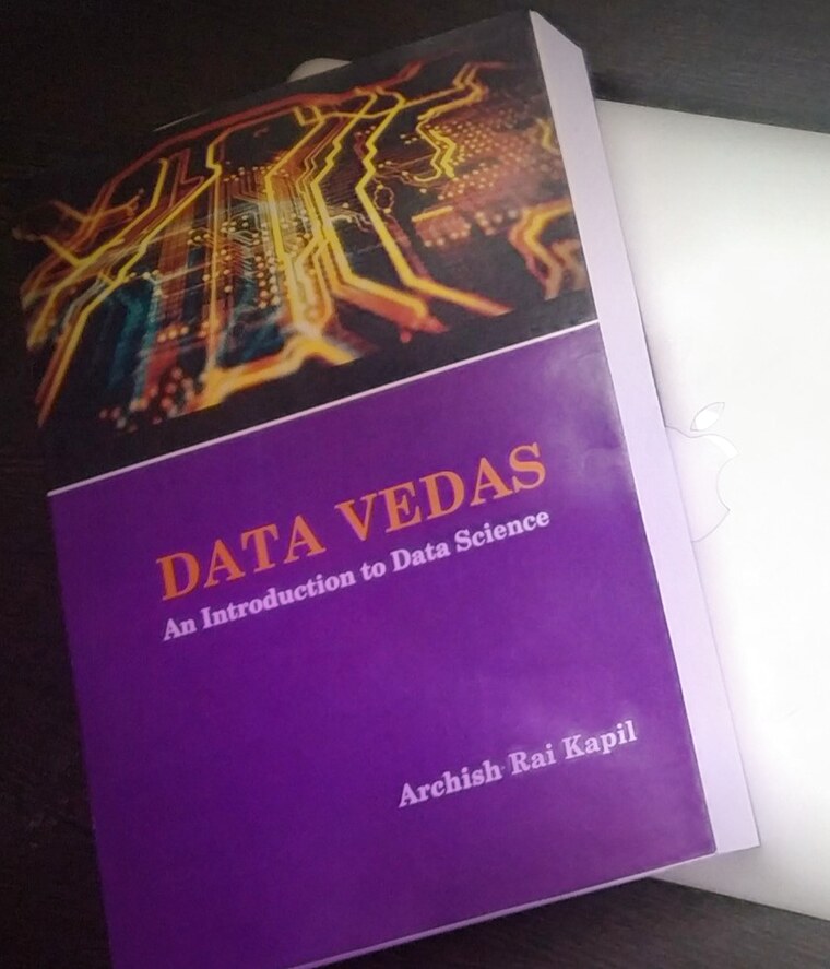 The printed paperback edition of DataVedas, resting on a laptop